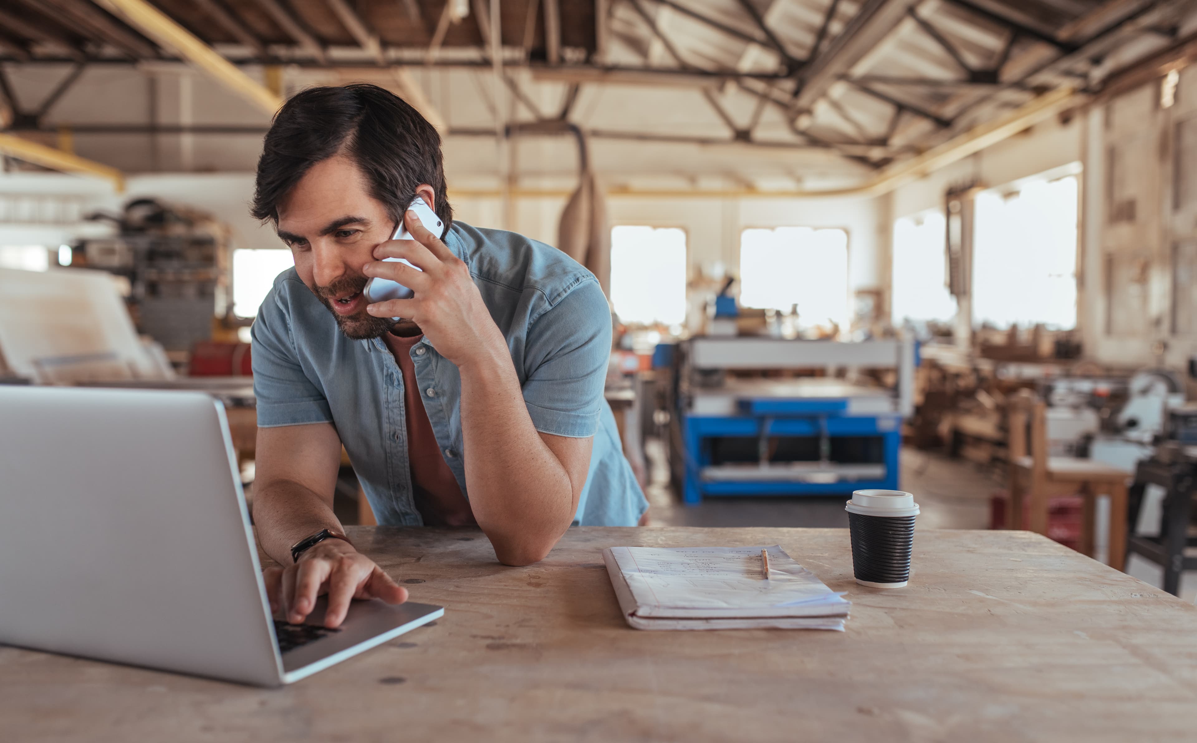 Small business owner working on laptop in workshop